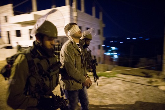 חיילים עוצרים פלסטיני בלילה (נתי שוחט / פלאש90)