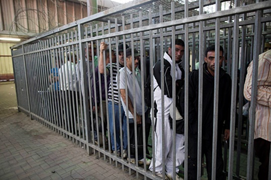 פלסטינים בעלי היתר כניסה לישראל ב"כלוב" במחסום קלנדיה (יונתן זינדל/ פלאש90)