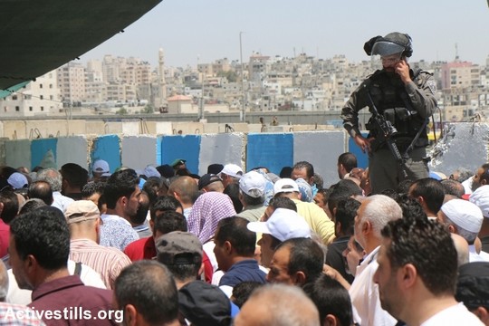 פלסטינים מהגדה המערבית חוצים דרך מחסום קלנדיה בדרכם לתפילות יום השישי השני של הרמאדן במסגד אל אקצא בירושלים. 6 ביוני 2017 (צילום: אחמד אל-באז/אקטיבסטילס)