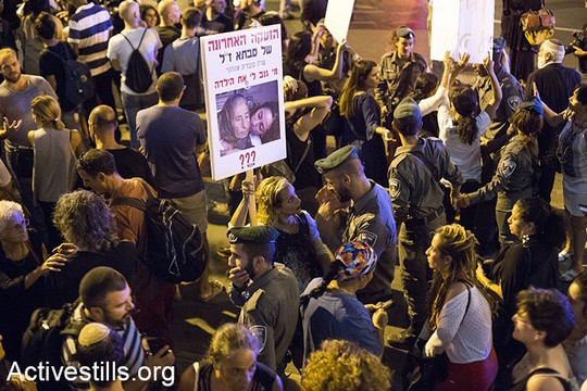 שוטר מול מפגינה על רחוב קפלן בתל אביב, הפגנת משפחות ילדי תימן (קרן מנור / אקטיבסטיילס)