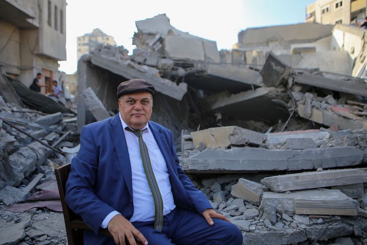 מנהל מרכז אל-משעל עלי אבו יאסין על רקע ההריסות. שימש בית לאמנים בעזה (צילום: מוחמד חג'אר)