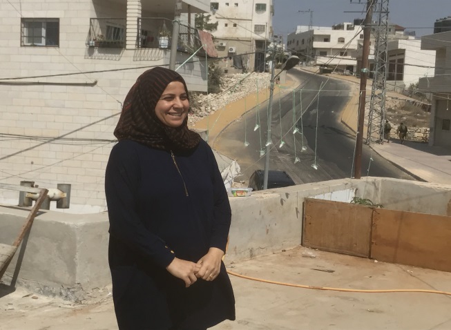 סוזאן ג'אבר על גג ביתה. ברקע ניתן לראות את הרחוב הראשי בשכונת ג'אבר הריק ממכוניות פלסטיניות (רמי יונס)