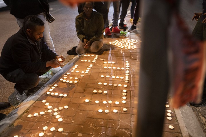 צעירים מדליקים נרות לזכרו של יהודה ביאדגה במקום בו נורה למוות על ידי שוטר. (אורן זיו)