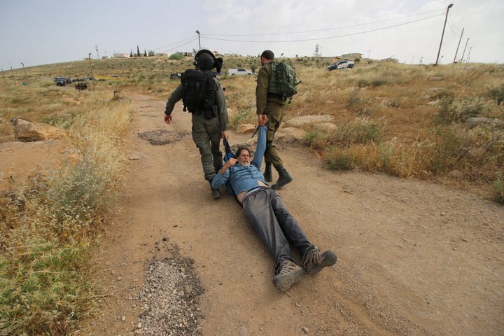 פעיל השמאל אריק אשרמן נגרר על הארץ בידי חיילים. הצילום ש"עלה" לאלבאז במעצר (צילום: אחד אלבאז / אקטיבסטילס)