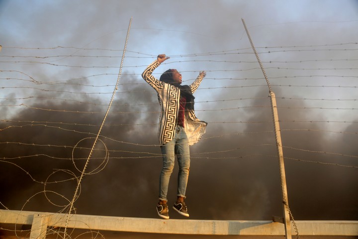 222 פלסטינים נהרגו מאש חיילים במחאות "מצעד השיבה". 11 מקרים נחקרו. צעירה פלסטינית על הגדר בין עזה לישראל במהלך הפגנות "צעדת השיבה" (צילום: מוחמד זאנון / אקטיבטילס)