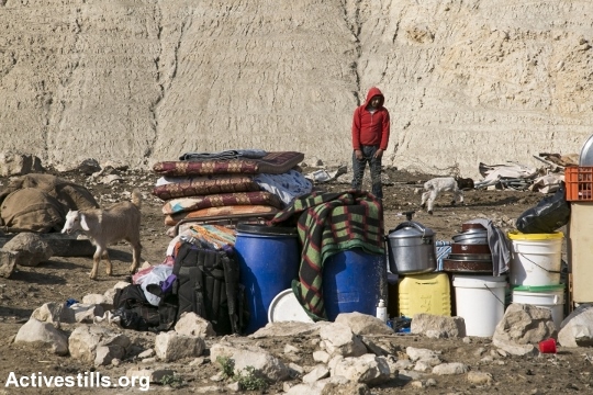 צעיר פלסטיני עומד ליד החפצים שהציל מביתו לאחר הריסת ביתו קרזליה, בקעת הירדן (אקטיבסטילס)