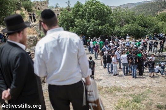 פליטים פלסטינים מהכפר הפלסטיני ״ליפתא״ מנציחים את זכר הנכבה, בעוד יהודים צופים בהם (יותם רונן/אקטיבסטילס)
