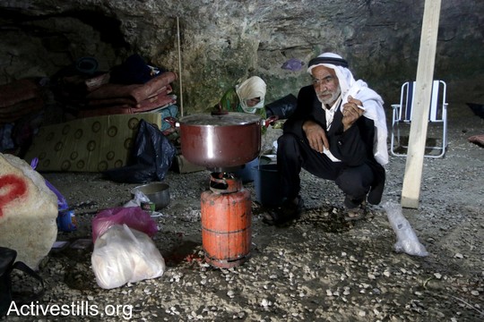פאדל אל עאמר, פלסטיני מזקני סארורה, מכין ארוחת ערב במערה שלו ששוקמה על ידי הפעילים. הפעילים הקימו את המאחז בכוונה לסייע לתושבי הכפר לחזור לבתיהם. "צומוד, מחנה החירות". הכפר סארורה הגדה המערבית, 24 במאי 2017 (צילום: אחמד אל-באז אקטיבסטילס)