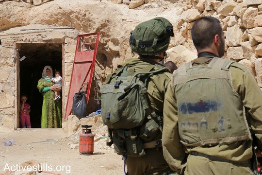 חיילים בכניסה למערה שמשמשת בית למשפחה מתושבי סארורה, במהלך ניסיון הפינוי השני של המאחז. "צומוד, מחנה החירות". הכפר סארורה הגדה המערבית, 25 במאי 2017 (צילום: אחמד אל-באז אקטיבסטילס)