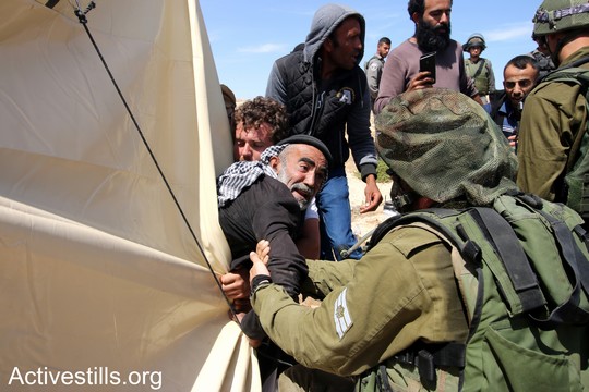 פלסטיני תושב סארורה מנסה להתנגד לניסיון הפינוי של הצבא. "צומוד, מחנה החירות". הכפר סארורה הגדה המערבית, 25 במאי 2017 (צילום: אחמד אל-באז אקטיבסטילס)