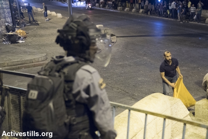 צעיר פלסטיני מנקה את הכביש בסיום תפילת הערב מחוץ לשער האריות, 26.7
