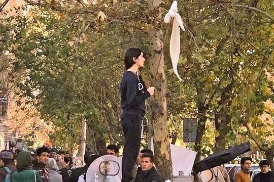 זה לא דגל לבן אלא תמצית האומץ להפר את סדר הדברים המעוות בפומבי. צעירה איראנית מניפה את כיסוי הראש שלה על מקל לעיני השוטרים ועומדת מולם גלויית ראש. גל הפגנות באיראן, סוף דצמבר 2017.