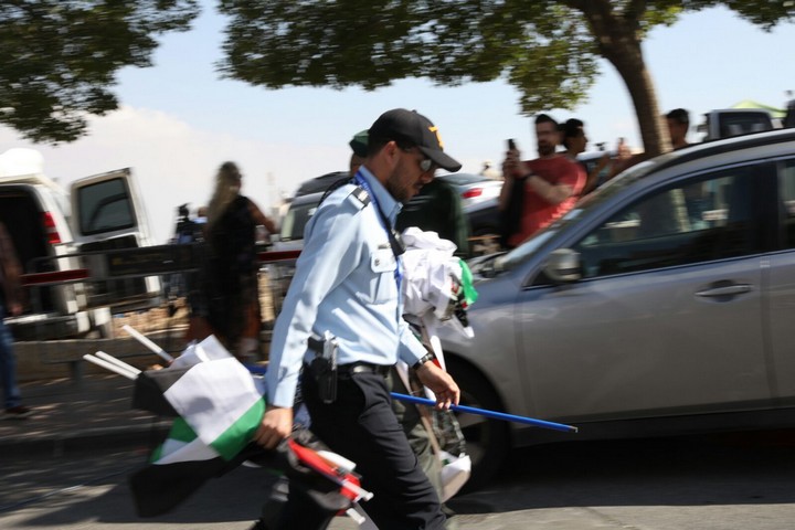 הפגנה נגד העברת שגרירות ארה"ב לירושלים. שוטר אוחז בדגלי פלסטין שהוחרמו באלימות מידי המפגינים. (אורן זיו / אקטיבסטילס)