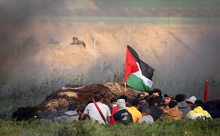 מפגינים בעזה מול הצלפים הישראלים מעבר לגדר. (צילום: עבד רחים ח'טיב/פלש90)
