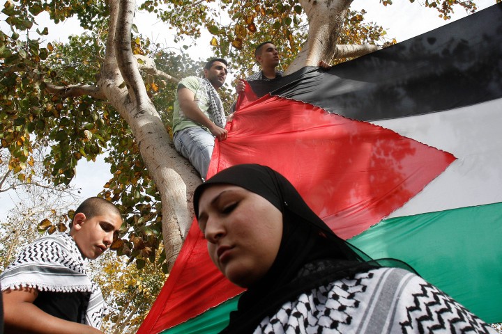 אשה נושאת דגל פלסטיני בהפגנת יום האדמה ביפו. הפלסטינים התפתחו כאן נגד הרצון הישראל (צילום: רוני שיצר/פלאש90)