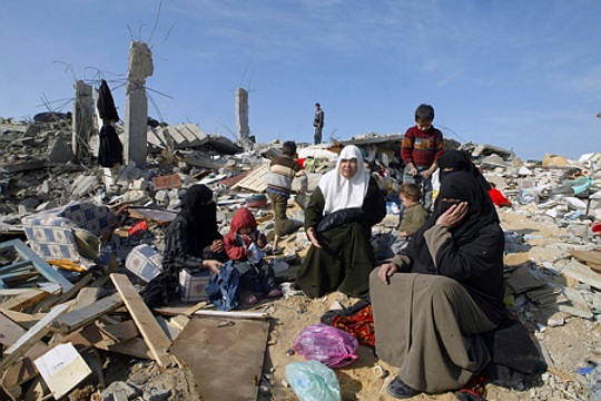 משפחה עזתית על חורבות ביתם ושכונתם שנחרבו בעופרת יצוקה, ינואר 2009 (עבד רחים ח'טיב/ פלאש 90)