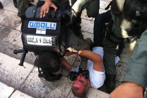 שוטרי מג"ב מפילים לרצפה פלסטיני שסרב להתפנות מרחבת שער שכם (צילום: מוריאל רוטמן)
