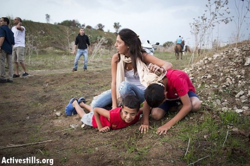 אם וילדיה מתכופפים בעת השמע אזעקה בתל אביב, 2012 (אקטיבסטילס)