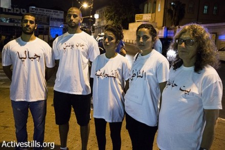 מפגינים ביפו לובשים חולצות עליהן כתובות שמות של שכונות שהופצצו בעזה. מימין לשמאל: בית חאנון, א-שאטי, שג'אעיה, חאן יונס, ג'בליה. 24 ביולי 2014. (קרן מנור/אקטיבסטילס)