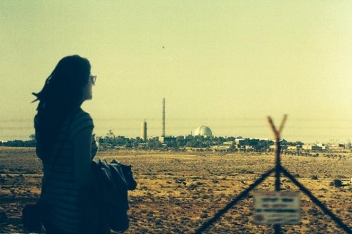 מיטל אבוקסיס על רקע הכור הגרעיני בדימונה (צילום באדיבות מיטל אבוקסיס)