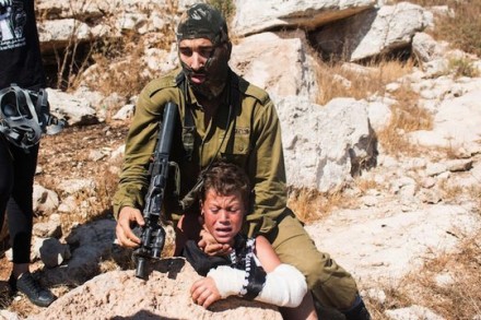 חייל תופס את מוחמד תמימי בן ה-12באלימות במהלך הפגנה בכפר נבי סלאח (צילום: כראם סלים)