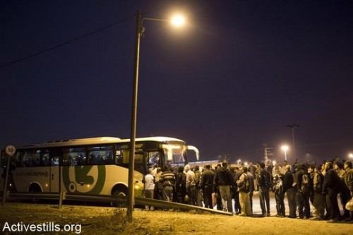 עובדים פלסטינים עומדים בתור להסעה לעבודה במחסום אייל. מרץ 2013 (אורן זיו/אקטיבסטילס)