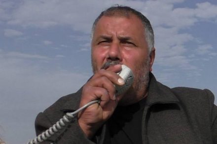 מוחמד אבו חומוס, אחד ממובילי המאבק הלא אלים בירושלים המזרחית, בפוזה אופיינית חמוש במגפון הפגנה בעיסאוויה. (צילום: גיא בוטביה)