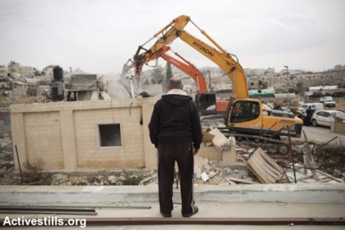 גבר פלסטיני מבוגר מביט בבולדוזרים של עיריית ירושלים ההורסים את ביתו בבית חנינה בשל ״בנייה לא חוקית״ (אקטיבסטילס)