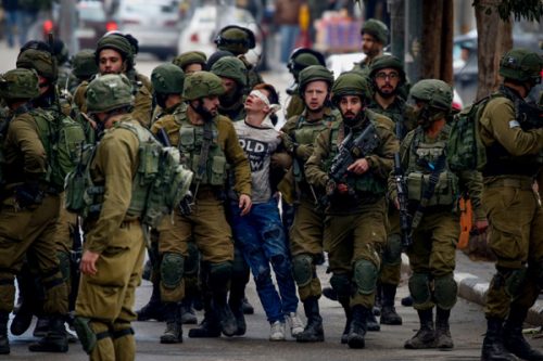 חיילים עוצרים נער פלסטיני בחברון בהפגנה בעקבות הכרזת טראמפ על ירושלים (ויסאם השלמון / פלאש90)