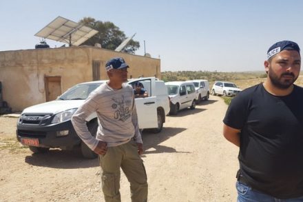שוטרים מלווים את אנשי רשות מקרקעי ישראל לחלוקת צווי פינוי והריסה לכל מבני ותושבי הכפר. 21 במרץ 2018 (רא'אד אבו אלקיעאן)