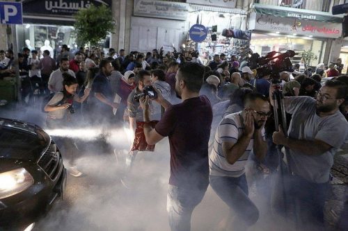 כוחות הבטחון הפלסטינים יורים רימוני הגז והלם לעבר מפגינים ועיתונאים. הפגנה ברמאללה בקריאה להסרת הסנקציות מעל עזה. (צילום באדיבות העמוד הפלסטיני "הסירו את הסנקציות")