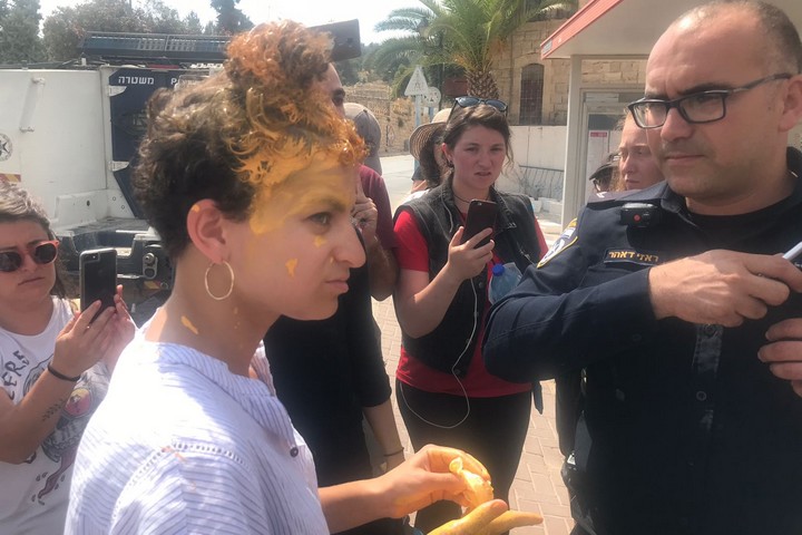 מרפי בוביס, מדריכת שוברים שתיקה, משוחחת עם שוטר לאחר שילד מקבוצת המתנחלים זרק צבע על ראשה במהלך סיור בחברון. 16 ביולי 2018 (צילום: מרב זונשיין)
