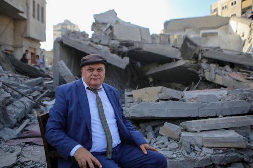מנהל מרכז אל-מסחאל עלי אבו יאסין על רקע ההריסות. שימש בית לאמנים בעזה (צילום: מוחמד חג'אר)