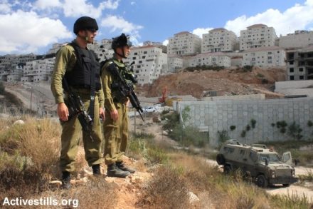 חיילים על רקע התנחלות בגדה. (צילום: אחמד אל-בז / אקטיבסטילס)