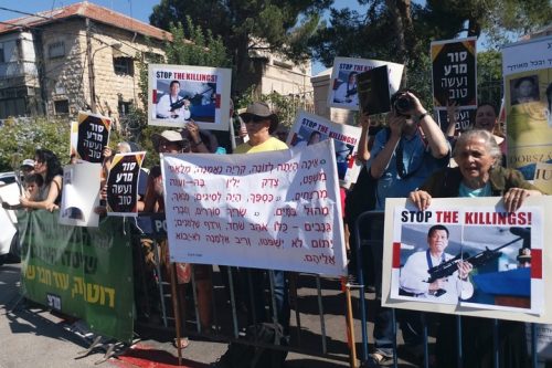"ישראל משתפת פעולה עם משטרו הדכאני של רודריגו דוטרטה, ונותנת יד להוצאות להורג ללא משפט, הפרות זכויות אדם חמורות, ותמיכה באונס". מפגינים ומפגינות נגד ביקורו של דוטרטה בישראל מול בית הנשיא בירושלים. 4 בספטמבר 2018 (חמושים)