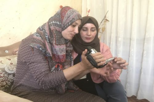 "אם לא הייתי מצלמת? הייתי מוצאת דרך לצלם. זו השליחות שלי". מנאל אל-ג'עברי ואריג' אל-ג'עברי צופות בסלון ביתהב של אריג' בוידאו שהיא צילמה (רמי יונס)