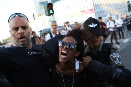 שוטרת עוצרת מפגינה במחאת יוצאי אתיופיה נגד אלימות משטרתית בתל אביב, 3.7.19 (אורן זיו / אקטיבסטילס)