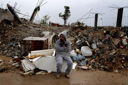 יש לך מזוודות שיכולות להכיל את הקירות? גבר יושב ליד הריסות ביתו אחרי הפצצה בעזה (צילום: עבד רחים ח'טיב / פלאש 90)